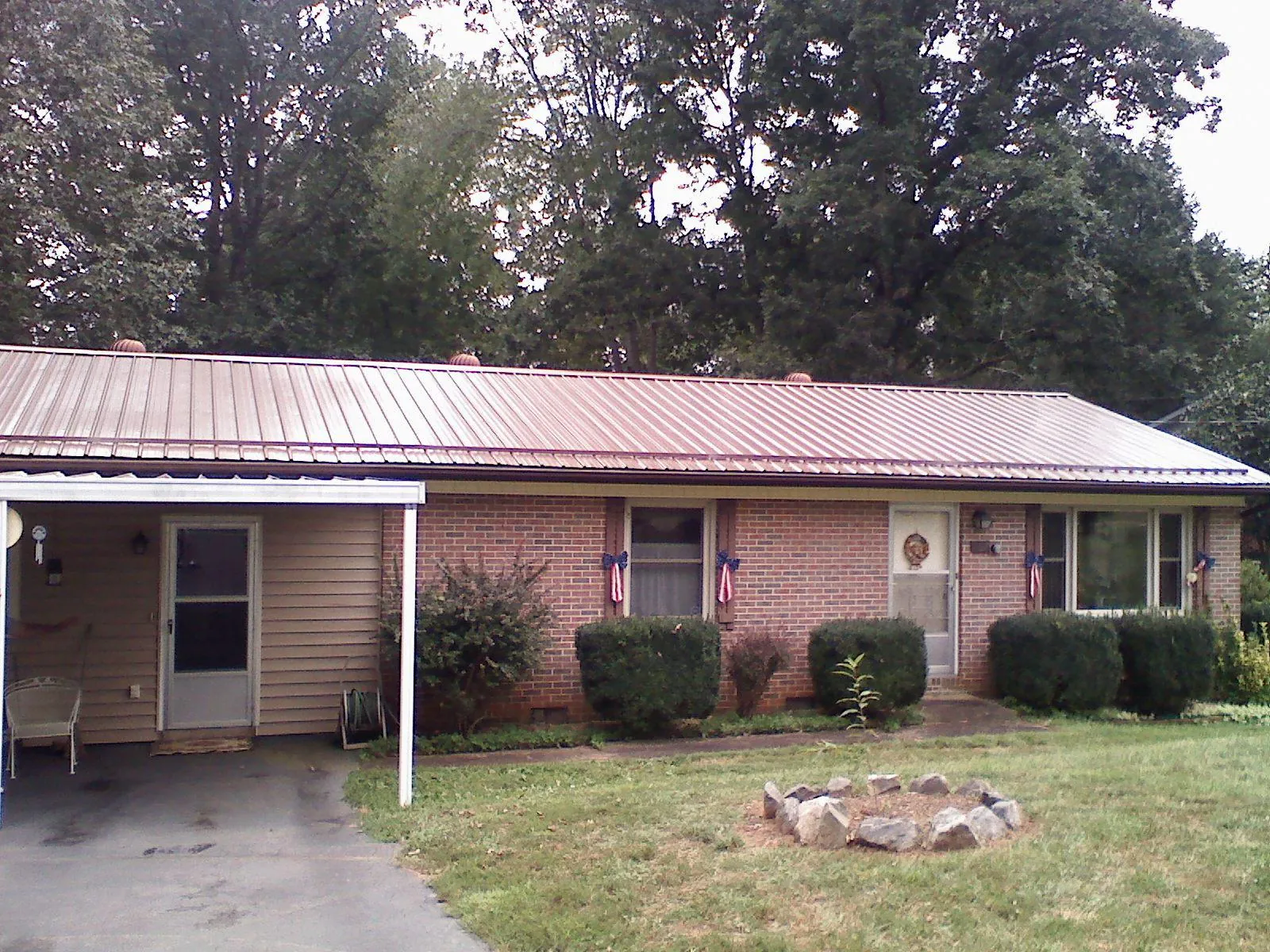 Bronze metal roof and carport on a brick ranch home — Roof Repair work by our crew in Fort Stewart