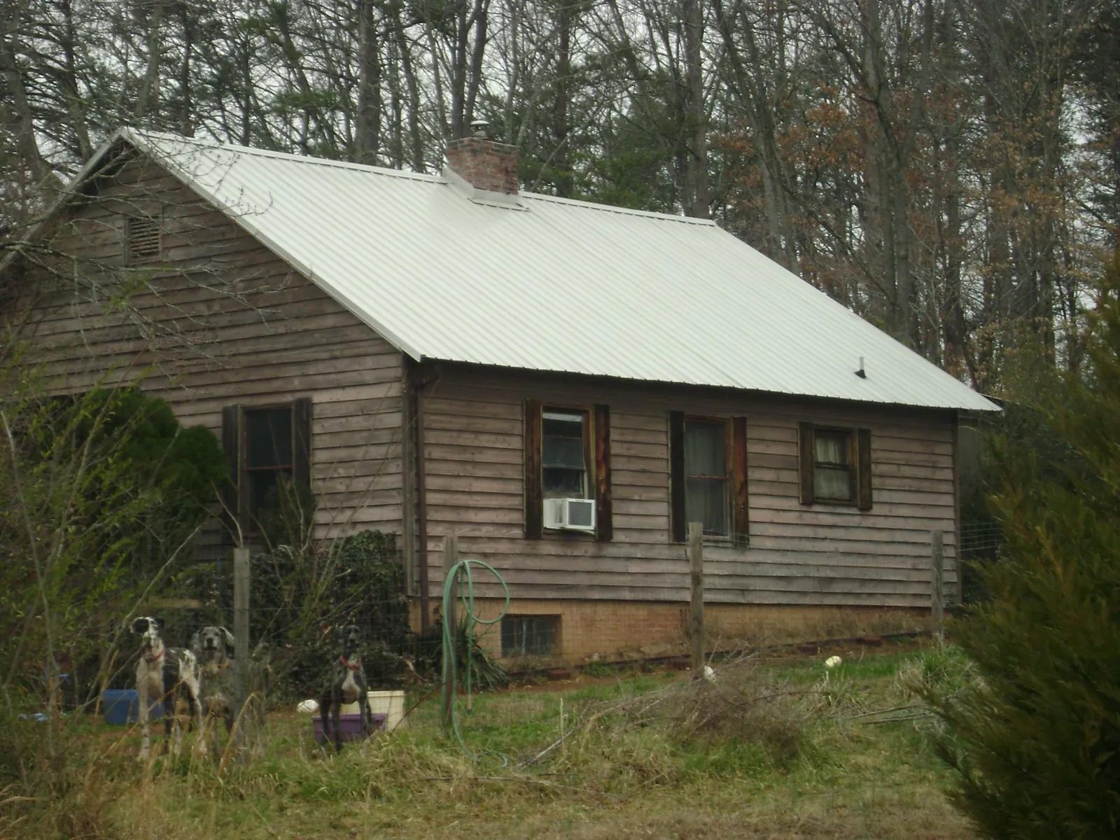 White metal roof on an old wood sided farmhouse, from a Metal Roof Installation job in Fort Stewart